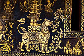 Wat Xieng Thong temple in Luang Prabang, Laos. Detail of the  intricate gold stencilling on black lacquer that decorate the walls of the sim.